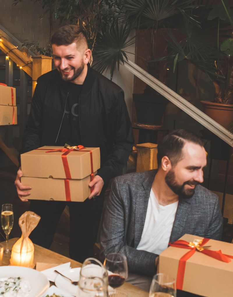 One of Apptension's bosses, Zbigniew, giving away present boxes at Christmas party, another Apptensian visible on the right